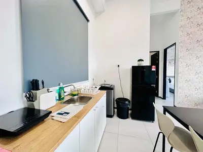 a kitchen with a sink and a black refrigerator at Luxury suites UB 3br 10 pax in Jelutong