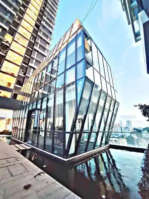 a glass building on the water in front of a building at Luxury suites UB 3br 10 pax in Jelutong