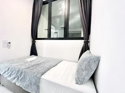 a bed in a room with a window at Urban Rooftop veiw PENANG 3br 10 pax in Jelutong