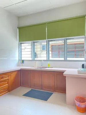 a large kitchen with a sink and two windows at 8 pax KakaHomestay Tmn Petani Jaya in Sungai Petani