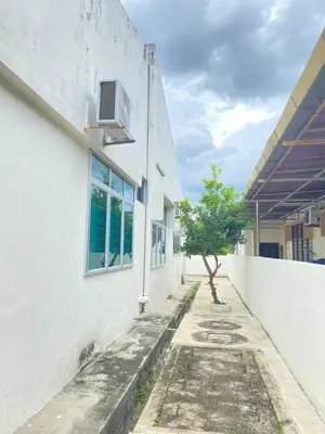 a building with a tree on the side of it at 8 pax KakaHomestay Tmn Petani Jaya in Sungai Petani