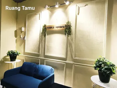 a room with a blue couch and plants on the wall at D Nabils Homestay Musslim Sahaja in Kulim