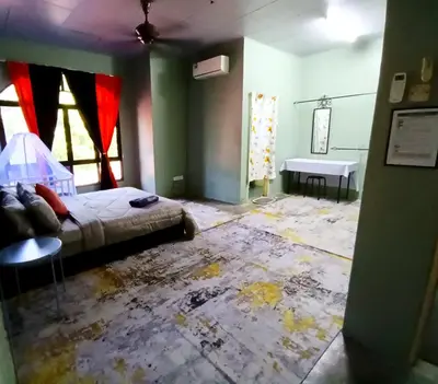 a bedroom with a bed and a table in a room at D Nabils Homestay Musslim Sahaja in Kulim