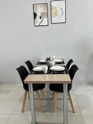 a dining room table with black chairs and a white wall at Ipoh Cozy Stay Near Town & Park in Ipoh