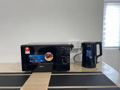 a toaster oven sitting on a counter next to a coffee pot at Ipoh Cozy Stay Near Town & Park in Ipoh