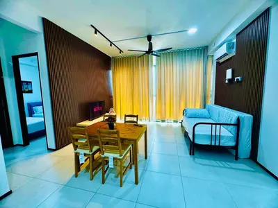 a living room with a table and a couch at Cozy with Sea & City Views 3BR 12PAX in Jelutong
