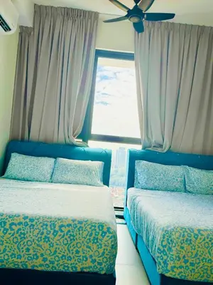 a bedroom with two beds and a window at Luxury Suites with Sea & City Views 3BR 12PAX in Jelutong