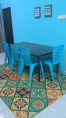 a blue table and four chairs on a colorful floor at Homestay RestUI, Kepala Batas Penang, 4km dari Tol Bertam in Kepala Batas