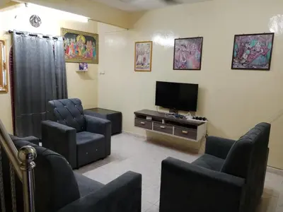 a living room with two chairs and a flat screen tv at Krishna Villa in Simpang