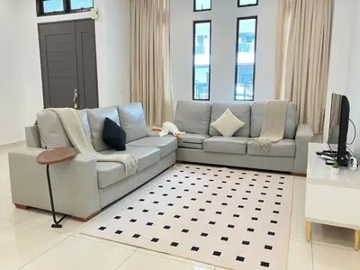 a living room with a couch and a television at Chicken Little 4-bedroom home with free parking! Available for Business Trip in Kampong Lima Kongsi