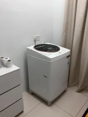 a small washing machine sitting in a room at Chicken Little 4-bedroom home with free parking! Available for Business Trip in Kampong Lima Kongsi