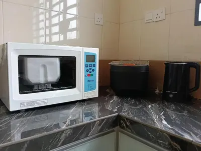 a microwave sitting on a counter with a trash can at Luxurious Noble Homestay in Sungai Petani