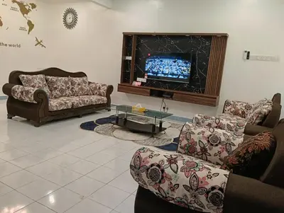 a living room with couches and a flat screen tv at Luxurious Noble Homestay in Sungai Petani