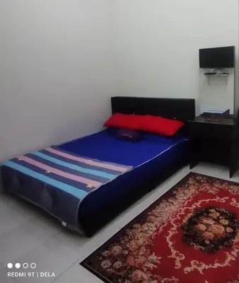 a bedroom with a blue bed with a red pillow at FDhomestay in Kampung Baharu Batu Dua