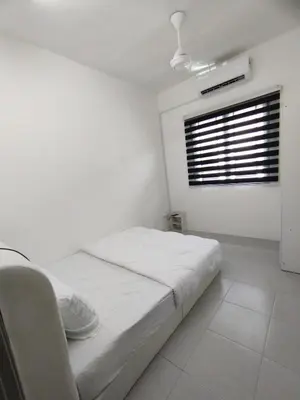 a white bedroom with a bed and a window at Lilly Grove Homestay in Kampong Ayer Melintas Besar