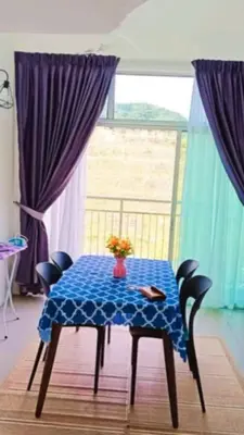 a blue table with chairs and a vase of flowers on it at Cahaya homestay Penthouse Cameron Highlands in Brinchang