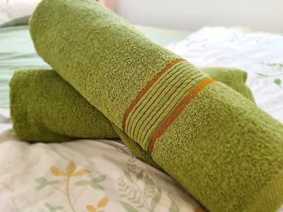 a stack of green pillows on a bed at Lunas Kulim Hi Tech BKE Q Comfort in Kubang Semang