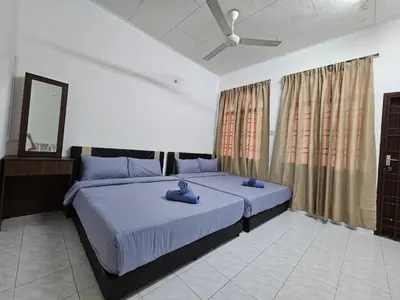 a bedroom with a large bed with blue towels on it at Sunrise Hostel in Ipoh