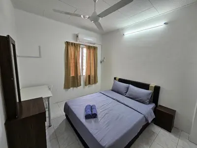 a bedroom with a bed with blue shoes on it at Sunrise Hostel in Ipoh