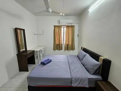 a bedroom with a bed with a blue pillow on it at Sunrise Hostel in Ipoh