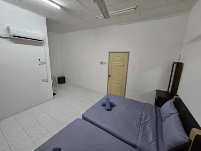 a room with a bed with two blue candles on it at Sunrise Hostel in Ipoh