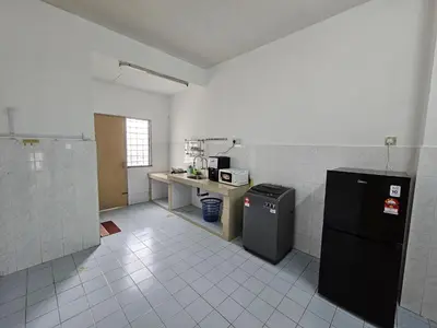 a kitchen with a refrigerator and a counter in it at Sunrise Hostel in Ipoh