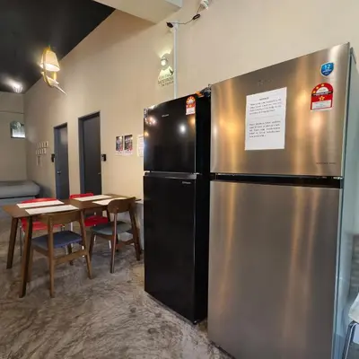a large stainless steel refrigerator in a room with a table at Wayton Cottage in George Town