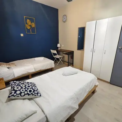 a room with two beds and a desk with a chair at Wayton Cottage in George Town