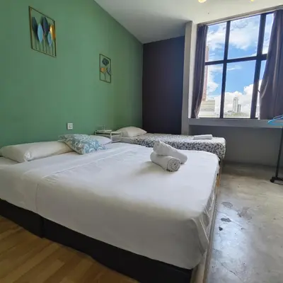 two twin beds in a room with a window at Wayton Cottage in George Town