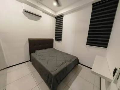 a small bedroom with a bed in a white room at Penang Urban Homestay in Jelutong