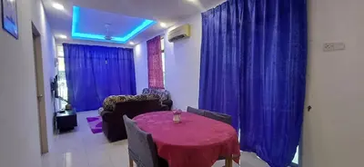 a living room with a table and blue curtains at River Truss Homestay in Nibung Tebal