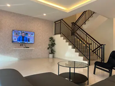 a living room with a staircase with a tv on the wall at Omari 2 Marina Island Homestay Lumut in Lumut