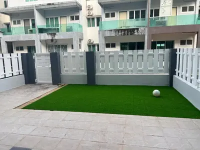 a soccer ball sitting on the grass in front of a building at Omari 2 Marina Island Homestay Lumut in Lumut