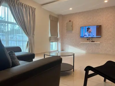 a living room with a couch and a tv on a wall at Omari 2 Marina Island Homestay Lumut in Lumut