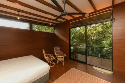 a bedroom with a bed and a table and a window at The HIJAU Camp & Cabin in Gopeng