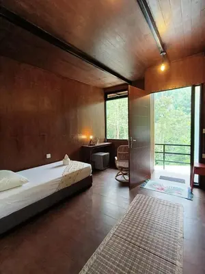 a bedroom with a bed and a desk and a window at The HIJAU Camp & Cabin in Gopeng