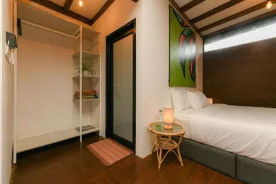 a bedroom with a bed and a table with a lamp at The HIJAU Camp & Cabin in Gopeng