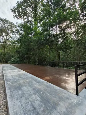 a wooden deck with a bench on top of it at The HIJAU Camp & Cabin in Gopeng