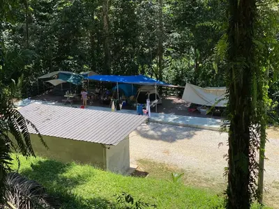 a tent with a blue roof in a forest at The HIJAU Camp & Cabin in Gopeng