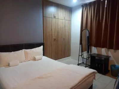 a bedroom with a bed and a wooden cabinet at Reintree Lodge Hotel Ipoh in Ipoh
