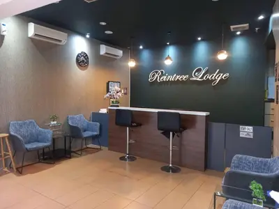 a waiting room with chairs and a bar with a sign at Reintree Lodge Hotel Ipoh in Ipoh