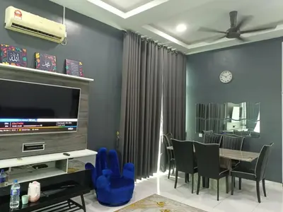 a dining room with a tv and a table and chairs at D'Sawah Homestay in Kampong Gunong Semanggol