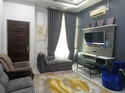 a living room with a tv and a couch and chairs at D'Sawah Homestay in Kampong Gunong Semanggol