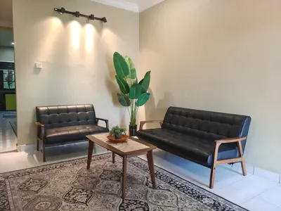 a living room with two leather couches and a coffee table at D'Cozy Homestay in Seri Manjung