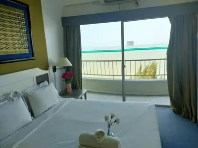 a bedroom with a white bed with a view of the ocean at Seaview appointment 3 bedroom in Tanjung Bungah