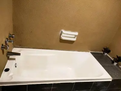 a white bath tub in a bathroom with a toilet at Seaview appointment 3 bedroom in Tanjung Bungah