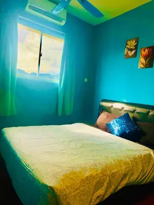 a blue bedroom with a bed and a window at 2br bayan lepas 1car park Malaysian guest only in Bayan Lepas
