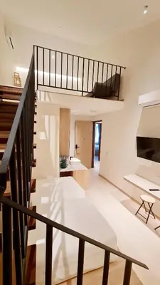 a living room with a staircase and white walls at Kazuki Boutique Accommodation in George Town