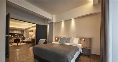 a bedroom with a bed and a living room at Tropics Eight Suites in George Town