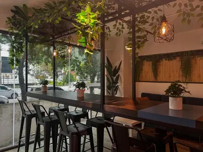 a bar in a restaurant with chairs and plants at Tropics Eight Suites in George Town